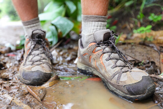 Hiking shoes on hiker in water puddle