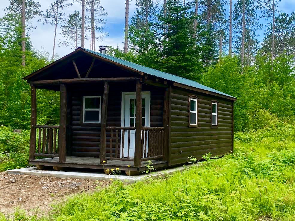 rustic Adirondack log cabin with green tin roof